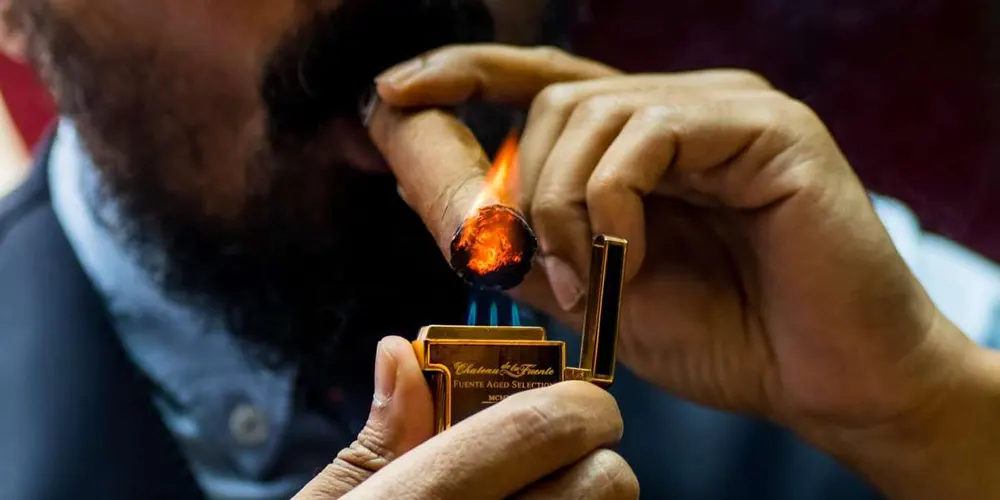 Mann zündet eine Zigarre mit einem Zigarrenfeuerzeug an